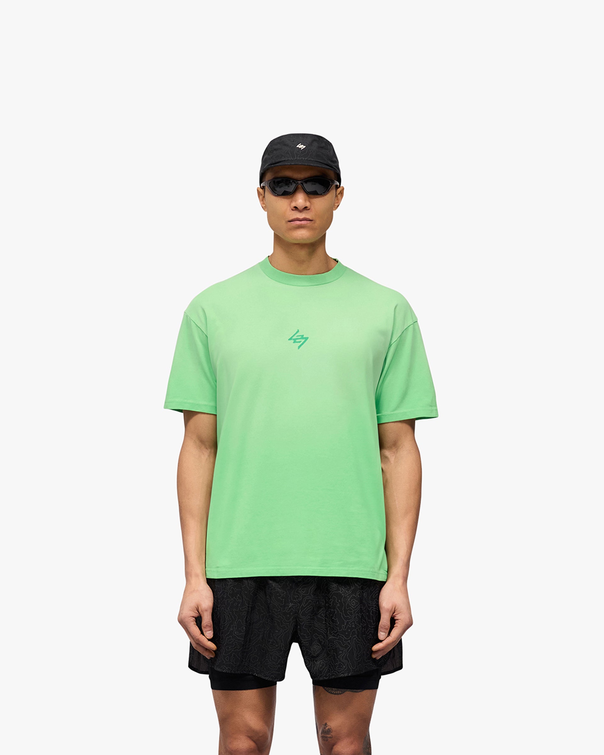 Man wearing an oversized green t-shirt on a plain white background | 247 Motion Oversized T-Shirt in Speed Green | T-Shirt with sweat wicking capability and fade out wash | 247 T-Shirts | Represent Clo