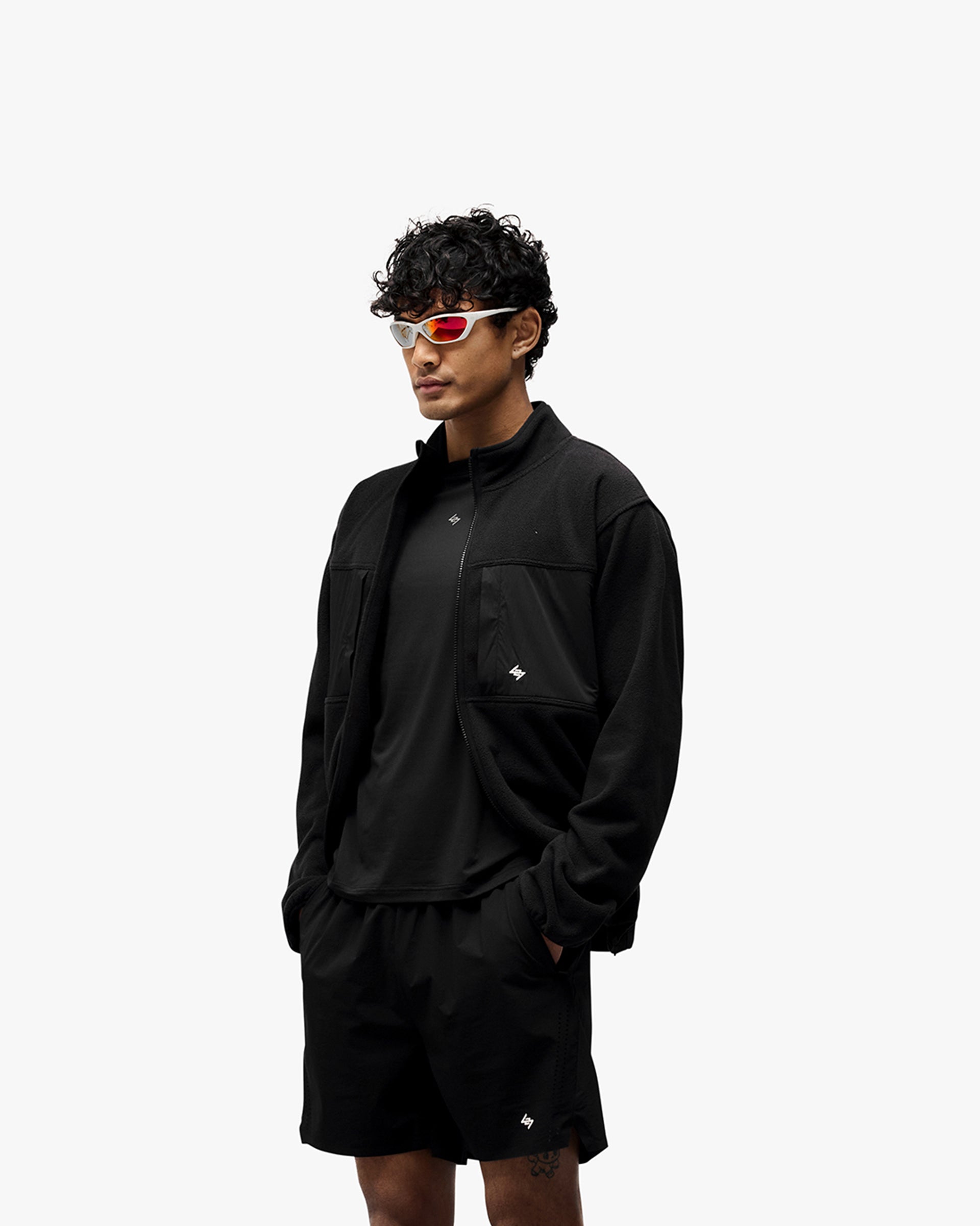Man wearing a black fleece on a plain white background | 247 Polar Panelled Fleece in Black | Fleece with four zip pockets and toggle hem | 247 Outerwear | Represent Clo