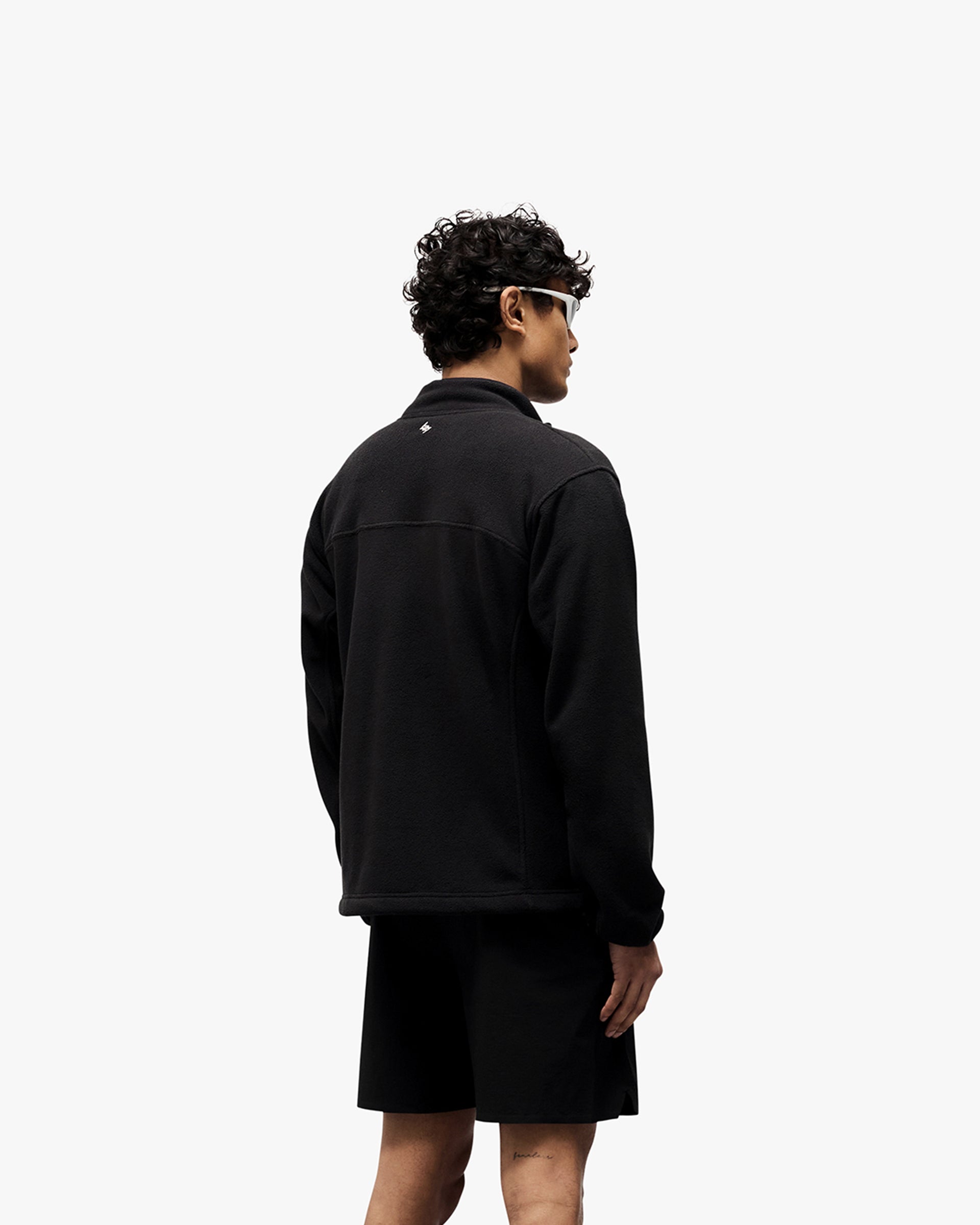 Man wearing a black fleece on a plain white background | 247 Polar Panelled Fleece in Black | Fleece with zip pockets and toggle hem | 247 Outerwear | Represent Clo
