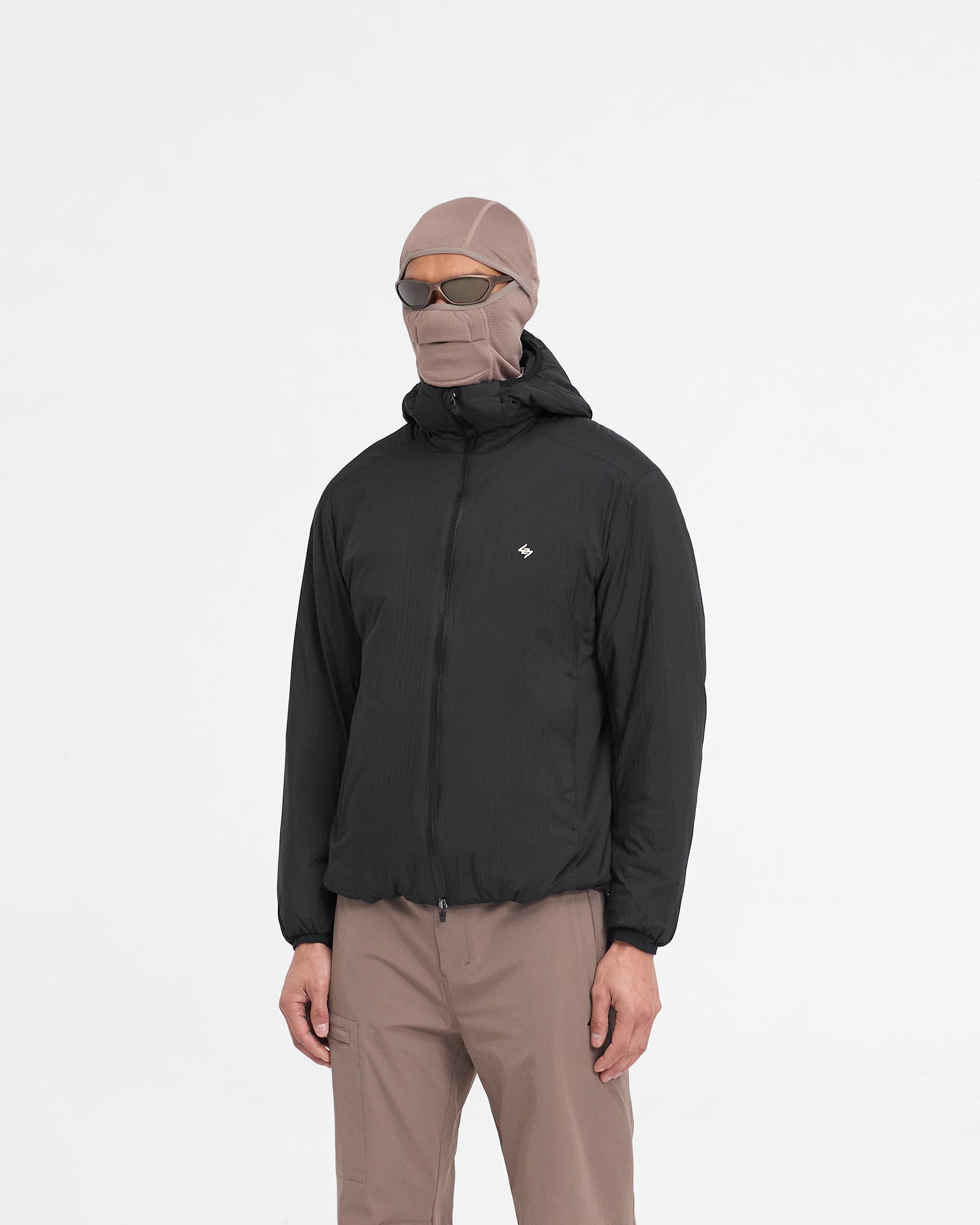 Man wearing a black insulated jacket on a plain white background | Team 247 Insulated Jacket in Black | Insulated jacket with DWR coating and adjustable features | 247 Outerwear | Represent Clo