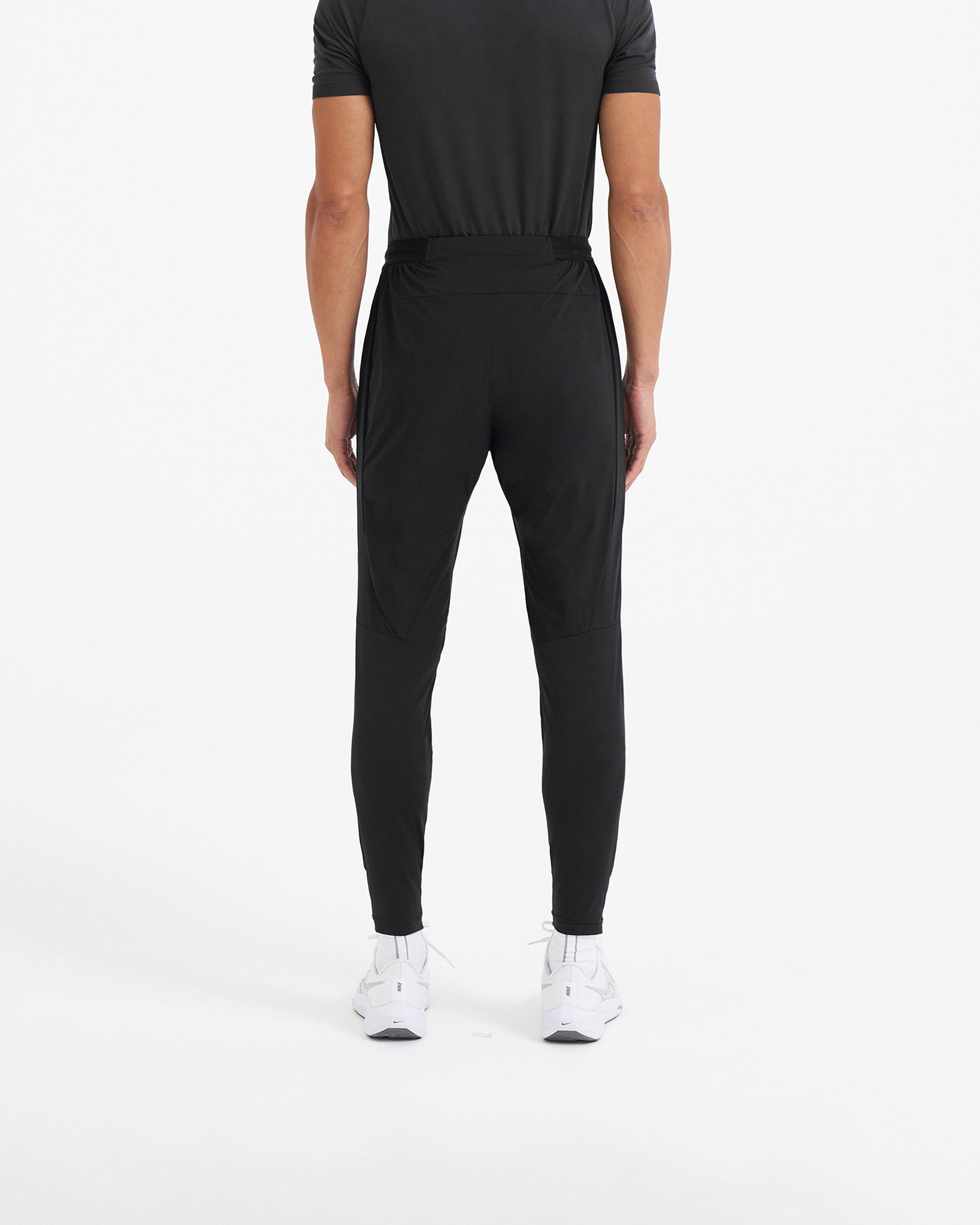 Man wearing black jogger pants on a plain white background | 247 Active Jogger in Black | 4-way stretch running pants with elasticated waistband | 247 Pants | Represent Clo