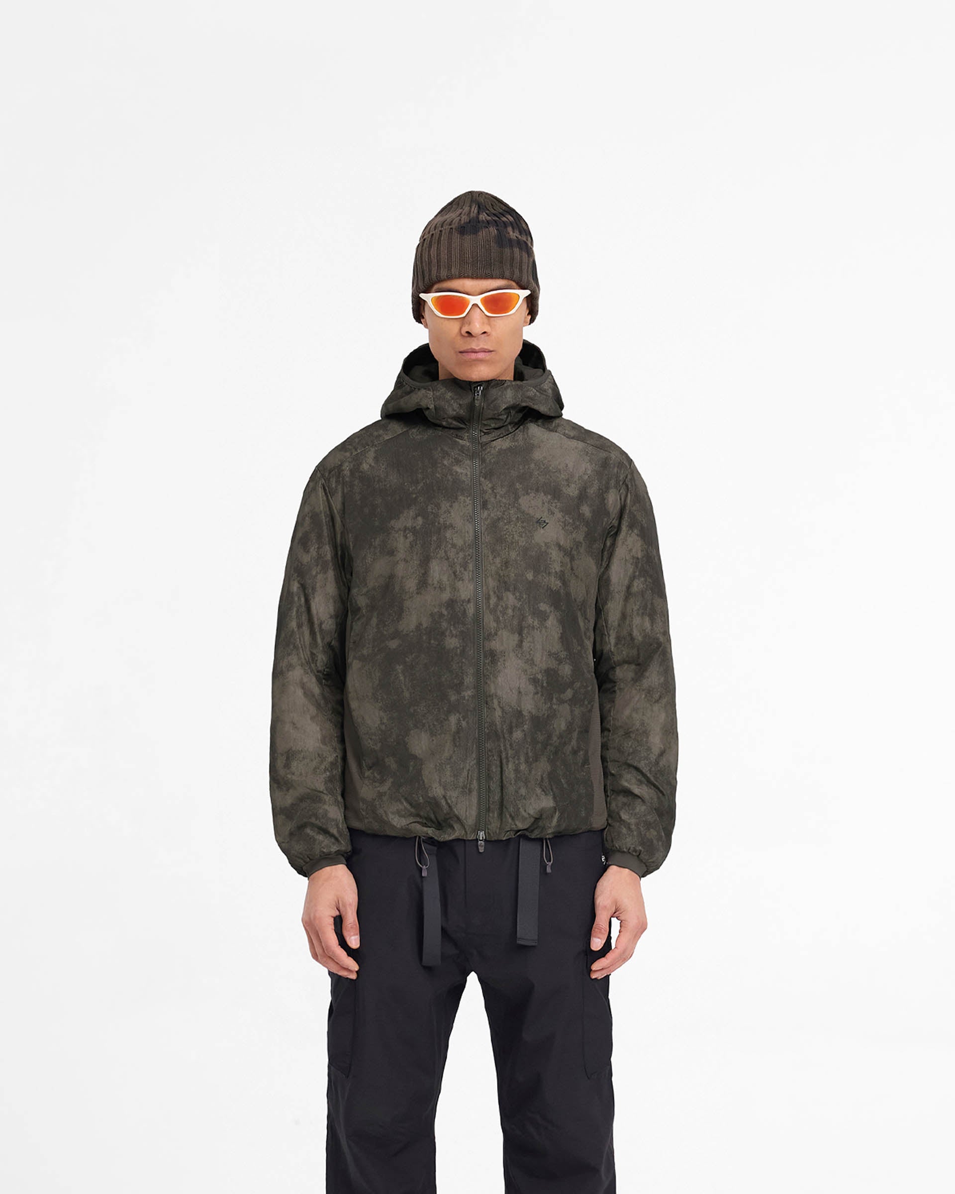 Man wearing a brown insulated jacket on a plain white background | Team 247 Insulated Jacket in Terrain | Insulated jacket with adjustable hood and gridded fleece panels | 247 Outerwear | Represent Clo