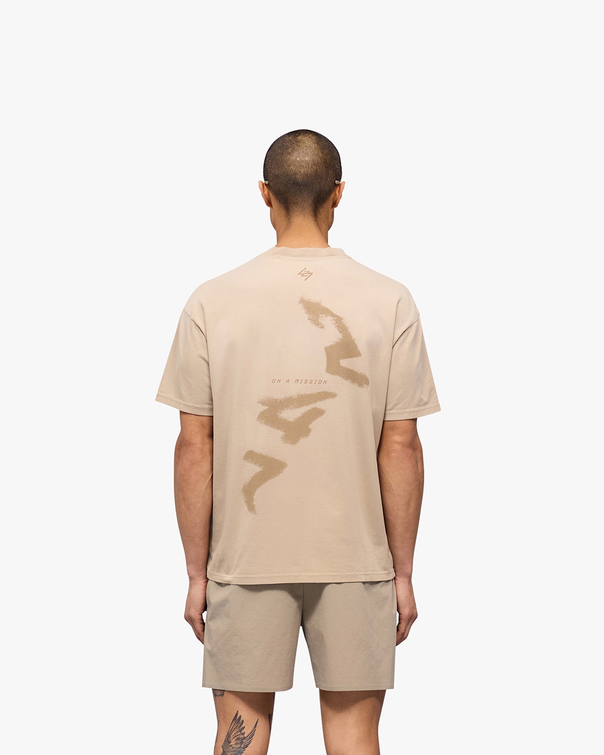 Man wearing an oversized grey t-shirt on a plain white background | 247 Motion Oversized T-Shirt in Pebble | Oversized t-shirt with sweat wicking and 2 way stretch | 247 T-Shirts | Represent Clo